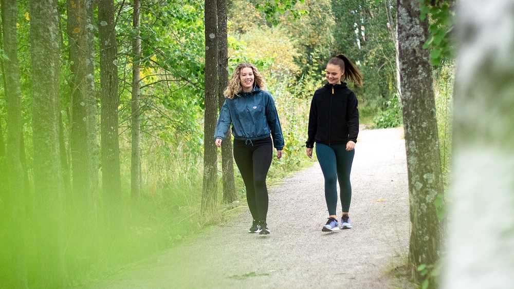 Ungdåmar på promenad i höstskogen.