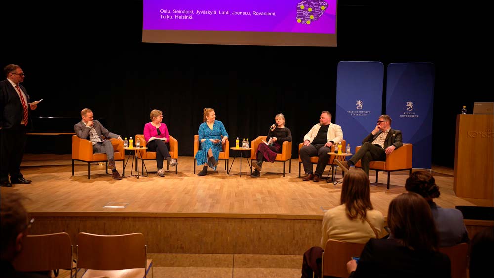 Keskustelijoita lavalla.