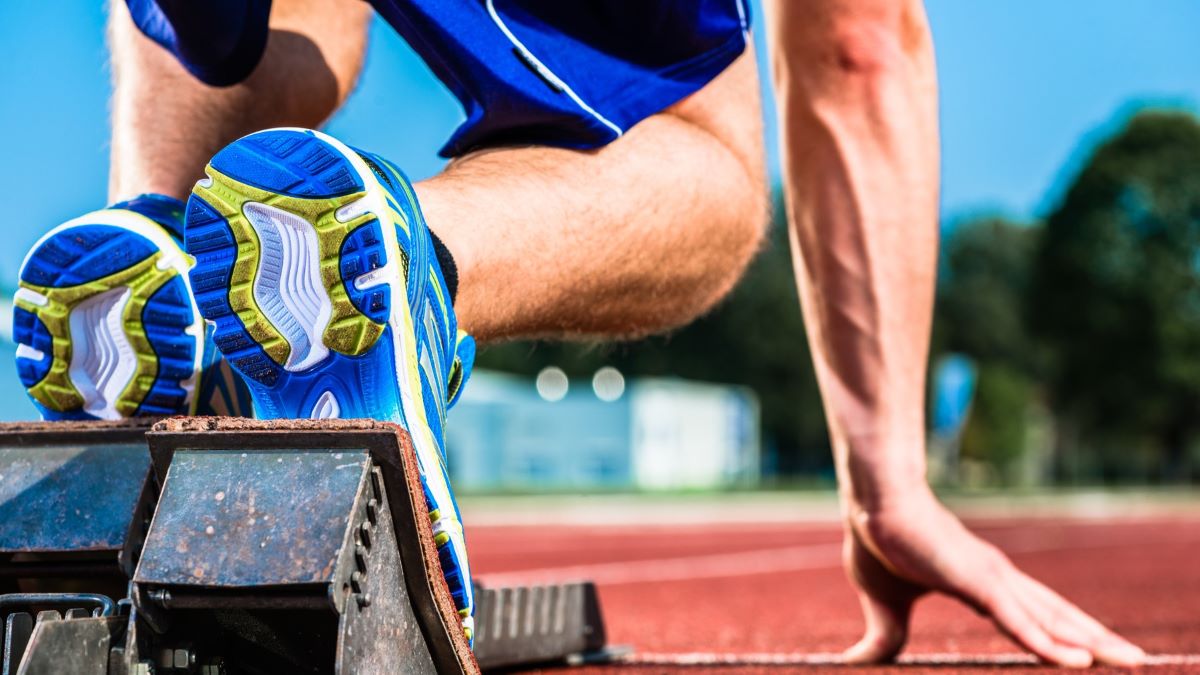 Kuvassa pikajuoksija lähtötelineellä.